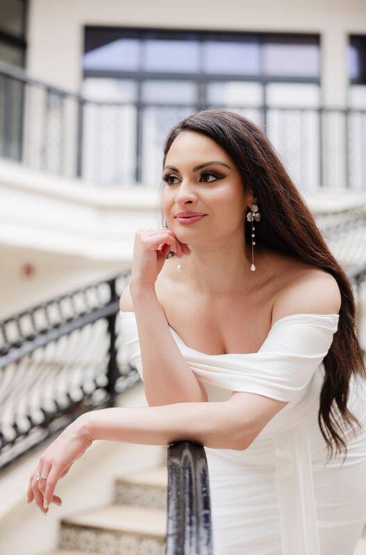 Iviani leaning on a balustrade, looking over her shoulder