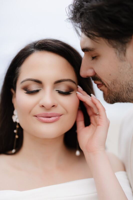 Iviani with her eyes closed as Joey rests his forehead against her temple