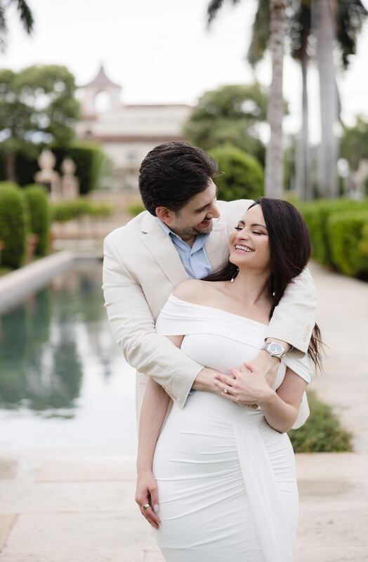 Joey hugging Iviani from behind by the reflecting pool