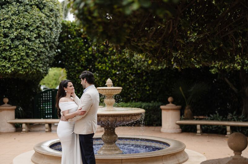 Iviani and Joey embracing beside the tiled fountain