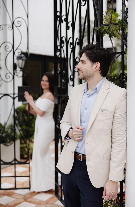Iviani and Joey in a doorway beside the iron gate