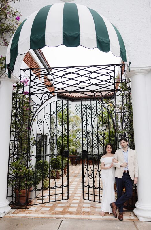 Iviani and Joey standing together beneath the striped awning