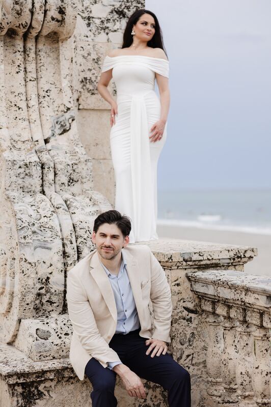 Iviani and Joey on the coral-stone wall by the sea